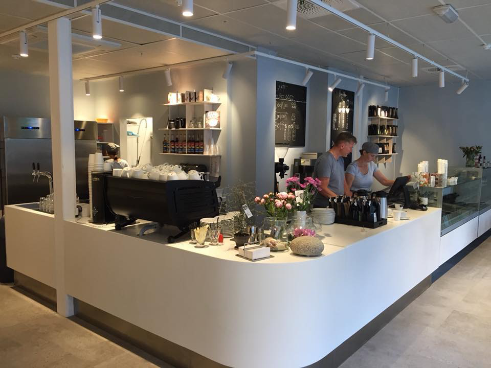 Innsiden av SVAL — disk med espressomaskin, blomster og baristaer